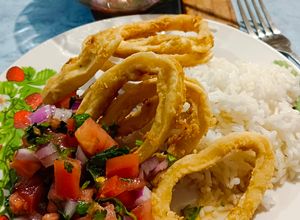 Una foto de Aros de calamar fritos con arroz y pebre