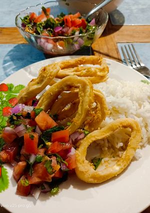 Una foto de Aros de calamar fritos con arroz y pebre