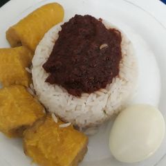 A picture of Boiled rice with tomato sauce,boiled plantain and egg.