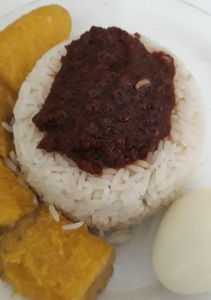 A picture of Boiled rice with tomato sauce,boiled plantain and egg.