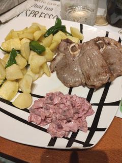 Una foto de Chuleta de pierna de cordero con patatas, pimientos y ensalada