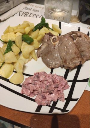 Una foto de Chuleta de pierna de cordero con patatas, pimientos y ensalada