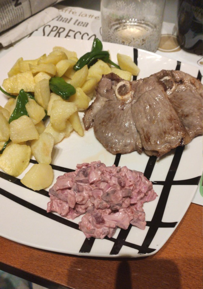 Una foto de Chuleta de pierna de cordero con patatas, pimientos y ensalada