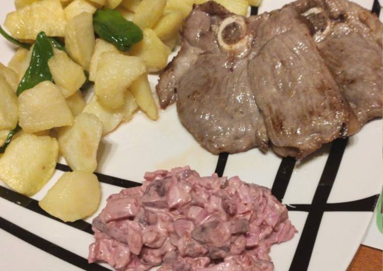 Chuleta de pierna de cordero con patatas, pimientos y ensalada
