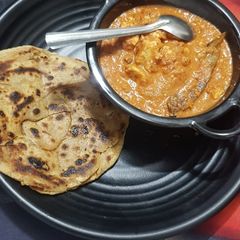 A picture of Shahi paneer with lacha paratha.