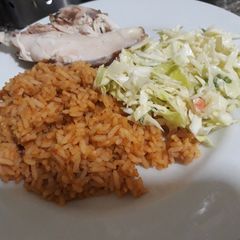 Jollof rice with coleslaw and chicken A picture of Jollof rice with coleslaw and chicken.