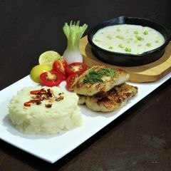 A picture of Butter Garlic Grilled Fish with white sauce.