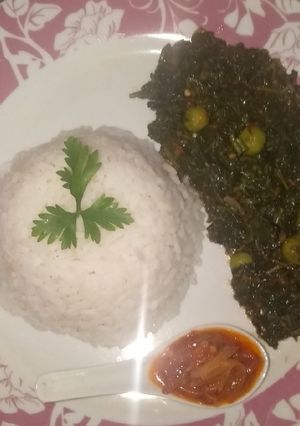 A picture of White rice and garden egg leaves soup.