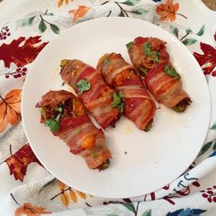 A picture of Chilorio Stuffed Jalapeno Peppers Wrapped in Bacon.