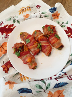 A picture of Chilorio Stuffed Jalapeno Peppers Wrapped in Bacon.