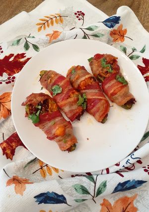 A picture of Chilorio Stuffed Jalapeno Peppers Wrapped in Bacon.