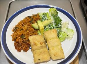 Una foto de *Pescado cazón crujiente con arroz chipotleado y ensalada cremosa con limón*
