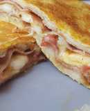 Sándwich envuelto en tortilla relleno de bacon y queso