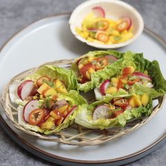 A picture of Honey, soy and lemon grass Pork with Mango in Lettuce cup.