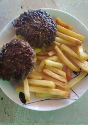 Una foto de Papas fritas con hamburguesa caseras
