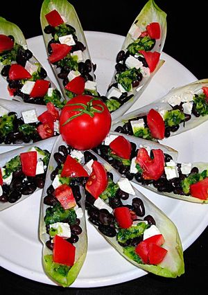 Una foto de Pétalos de endibias con alubias negras y queso de cabra