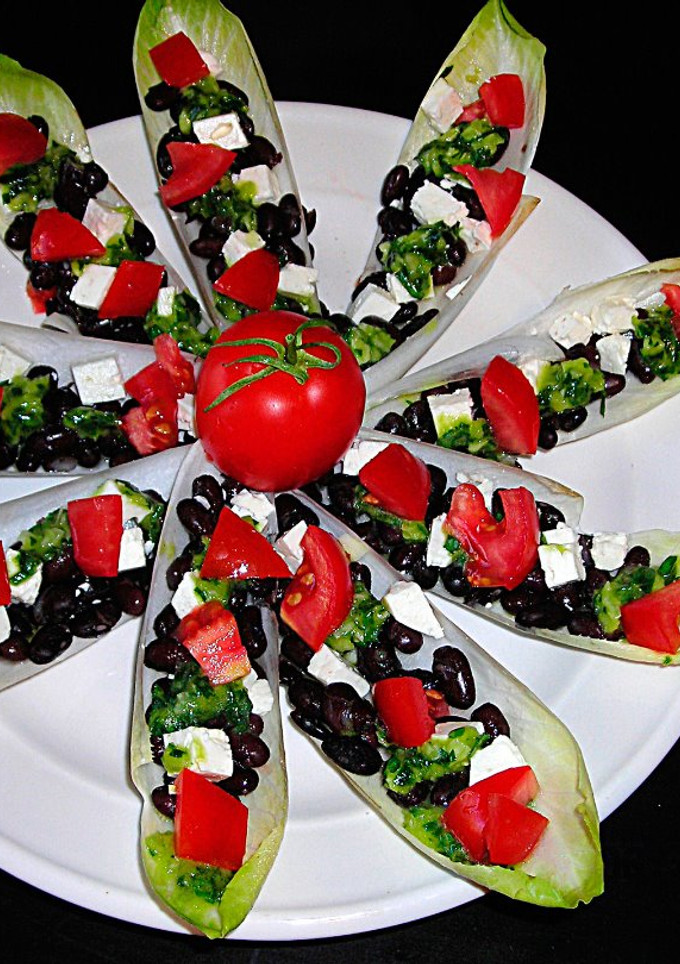 Una foto de Pétalos de endibias con alubias negras y queso de cabra