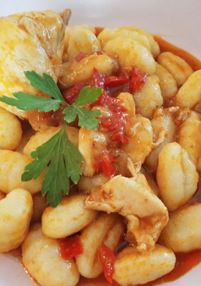 Una foto de Ñoquis con pollo al whisky en salsa de tomate