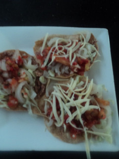 Una foto de Tostadas de cueritos encurtidos, salsa de birria y queso rallado rancheras. México