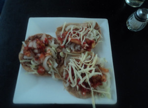 Una foto de Tostadas de cueritos encurtidos, salsa de birria y queso rallado rancheras. México