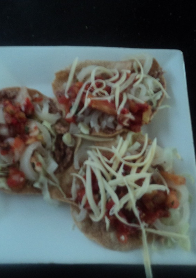 Una foto de Tostadas de cueritos encurtidos, salsa de birria y queso rallado rancheras. México