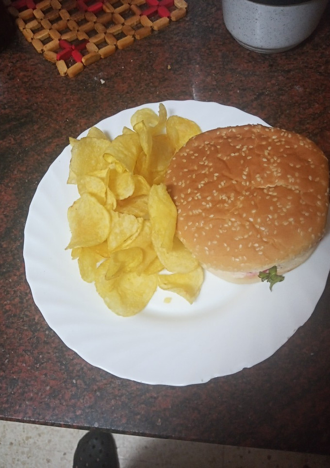 Una foto de Hamburguesa de pescado empanado, ensalada remolacha y huevo duro