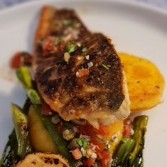 A picture of Sea bass sauce vierge and polenta.
