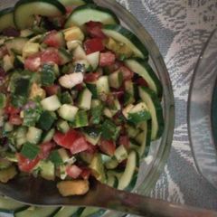 A picture of Cucumber, tomatoes, onions, avocado salad.