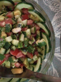 A picture of Cucumber, tomatoes, onions, avocado salad.