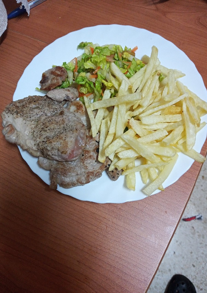 Una foto de Solomillo a la plancha con papas fritas y ensalada