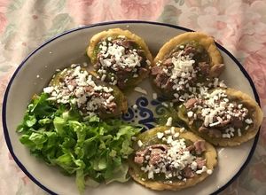 Una foto de Huaraches de frijol con salsa verde, bistec y queso