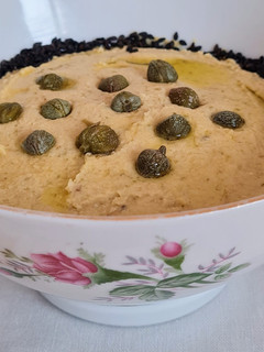 Una foto de Hummus con alcaparras y jengibre fresco