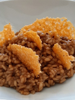 Una foto de Risotto de ajo negro y grana padano