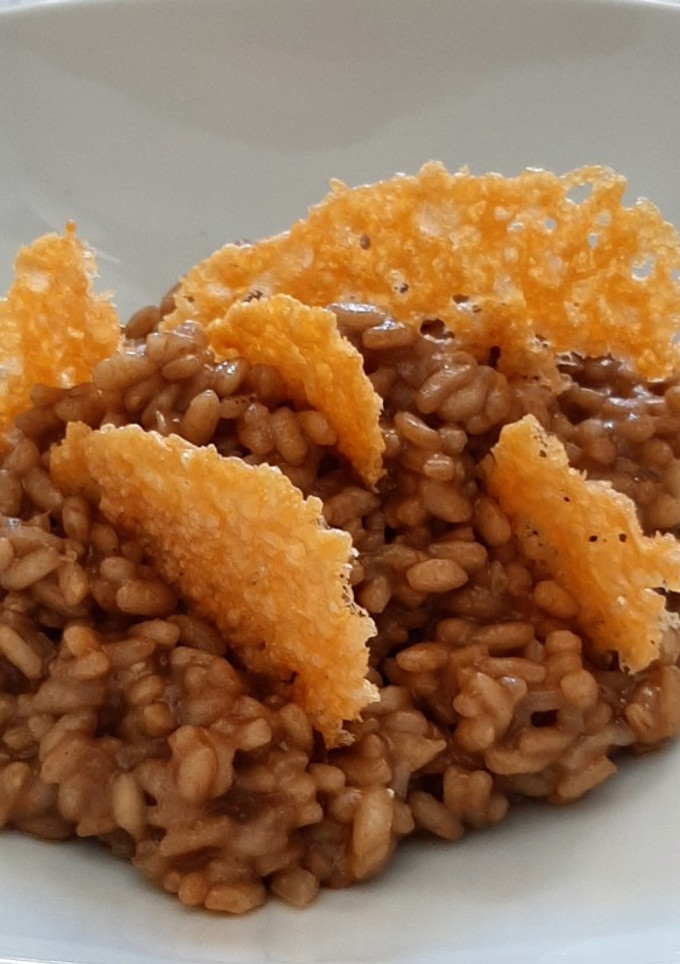 Una foto de Risotto de ajo negro y grana padano