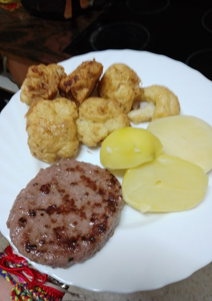 Una foto de Hamburguesa de cerdo a la plancha con coliflor rebozada y papas cocidas
