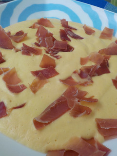 Una foto de Crema de manzana y verdura espolvoreada con jamón serrano
