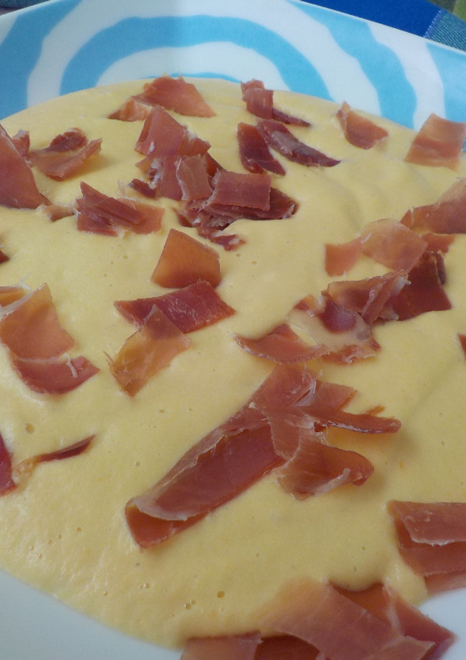 Una foto de Crema de manzana y verdura espolvoreada con jamón serrano