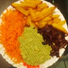 A picture of Potato wedges + guacamole+ carrots+ fried onions.