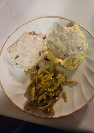 A picture of Pork chops with mushroom gravy.