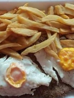 Una foto de Milanesas con huevos y papas fritas