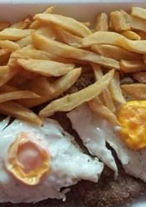 Una foto de Milanesas con huevos y papas fritas