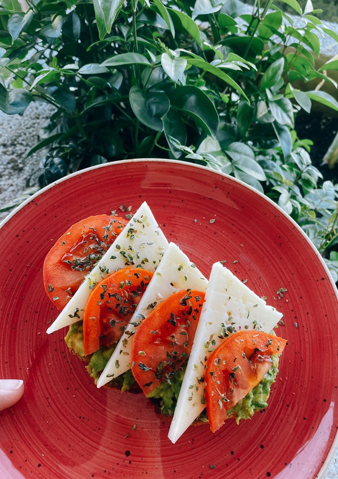Una foto de Tostada de pan de hogaza con aguacate, tomate, queso semi y orégano