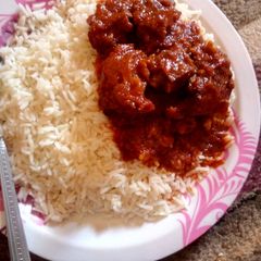 A picture of White rice,Tomato stew and meat.