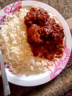 A picture of White rice,Tomato stew and meat.