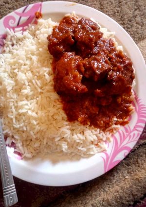 A picture of White rice,Tomato stew and meat.