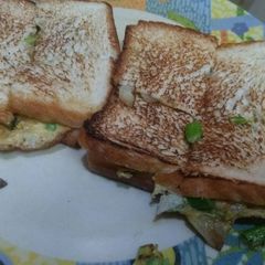 A picture of Onion omelette with bread slice.
