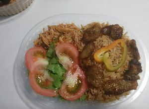 Una foto de Arroz amarillo con pollo ripiado, banana madura frita y ensalada