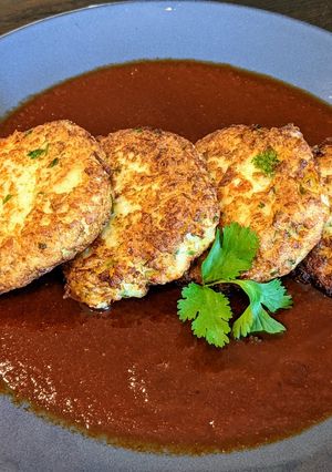 A picture of Cauliflower and cheese cakes in chile ancho sauce.