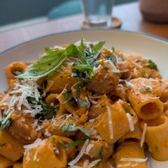 A picture of Pasta alla vodka, with pork and sprouts.