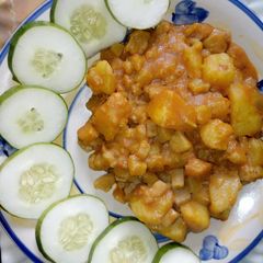 A picture of Unripe poridge plantain, sweet potatoes garnished with cucumber.